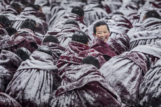 Trong một giờ học ngoài trời tại tu viện Labrang ở Tây Tạng, áo choàng của các nhà sư bị phủ đầy tuyết. Nhiếp ảnh gia Jianjun Huang đã may mắn ghi được khoảnh khắc một nhà sư quay lại với nụ cười rất tươi.